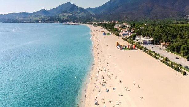 A beach with clear turquoise waters, a sandy shore, and a backdrop of mountains. - Villa in Le Boulou with Scenic Hilltop Views (Le Boulou)