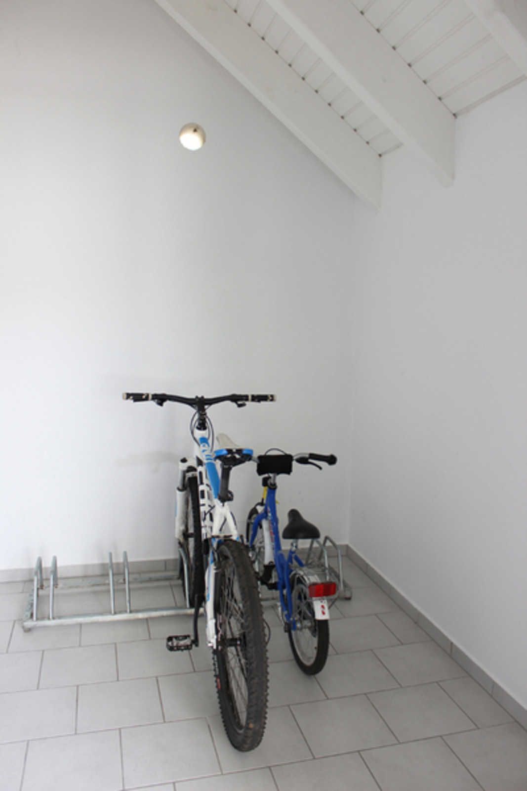 A clean, white-walled room with two bicycles parked against the wall.