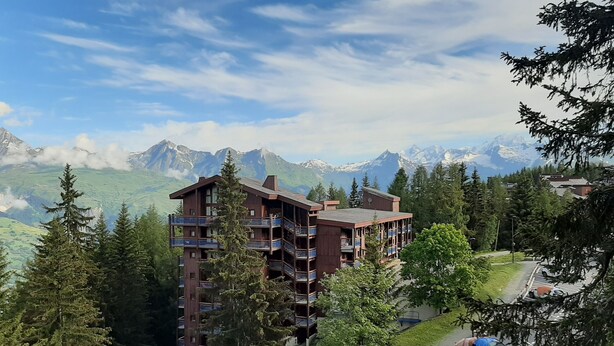 A multi-story hotel with balconies, surrounded by trees and mountains. - Arcs 1800, Vogel building, Mont-Blanc view, 200m from slopes and shops (Bourg-Saint-Maurice)
