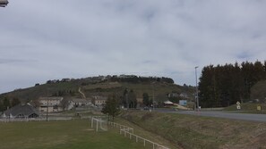 Ländliche Landschaft mit Hügel, Häusern und einer Straße.