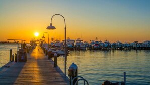 Un muelle con barcos atracados al atardecer.