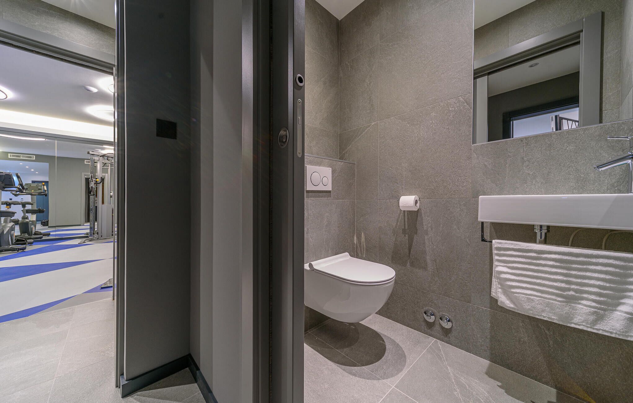 A modern bathroom with a toilet, sink, and shower area.