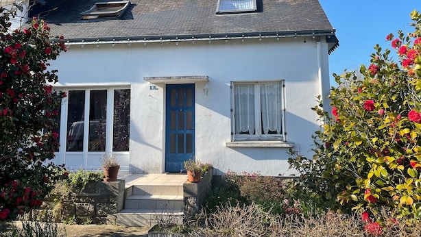 A white house with a blue door and windows, a chimney, and a small porch with potted plants. - lovely quiet house (Lanester)