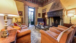 A spacious living room with a fireplace, comfortable seating, and a television.