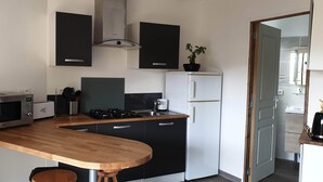 A compact kitchen with a microwave, toaster, gas stove, and a refrigerator. - BEAUTIFUL BRAND-NEW STUDIO APARTMENT (Le teich)