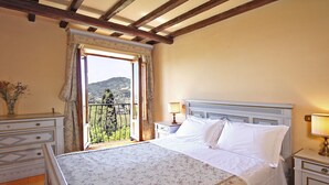 Une chambre à coucher comprenant un lit, une table de chevet, une commode et une fenêtre donnant sur l’extérieur.