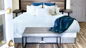 Ein Schlafzimmer mit Bett, Bank, Deckenventilator und Tür.