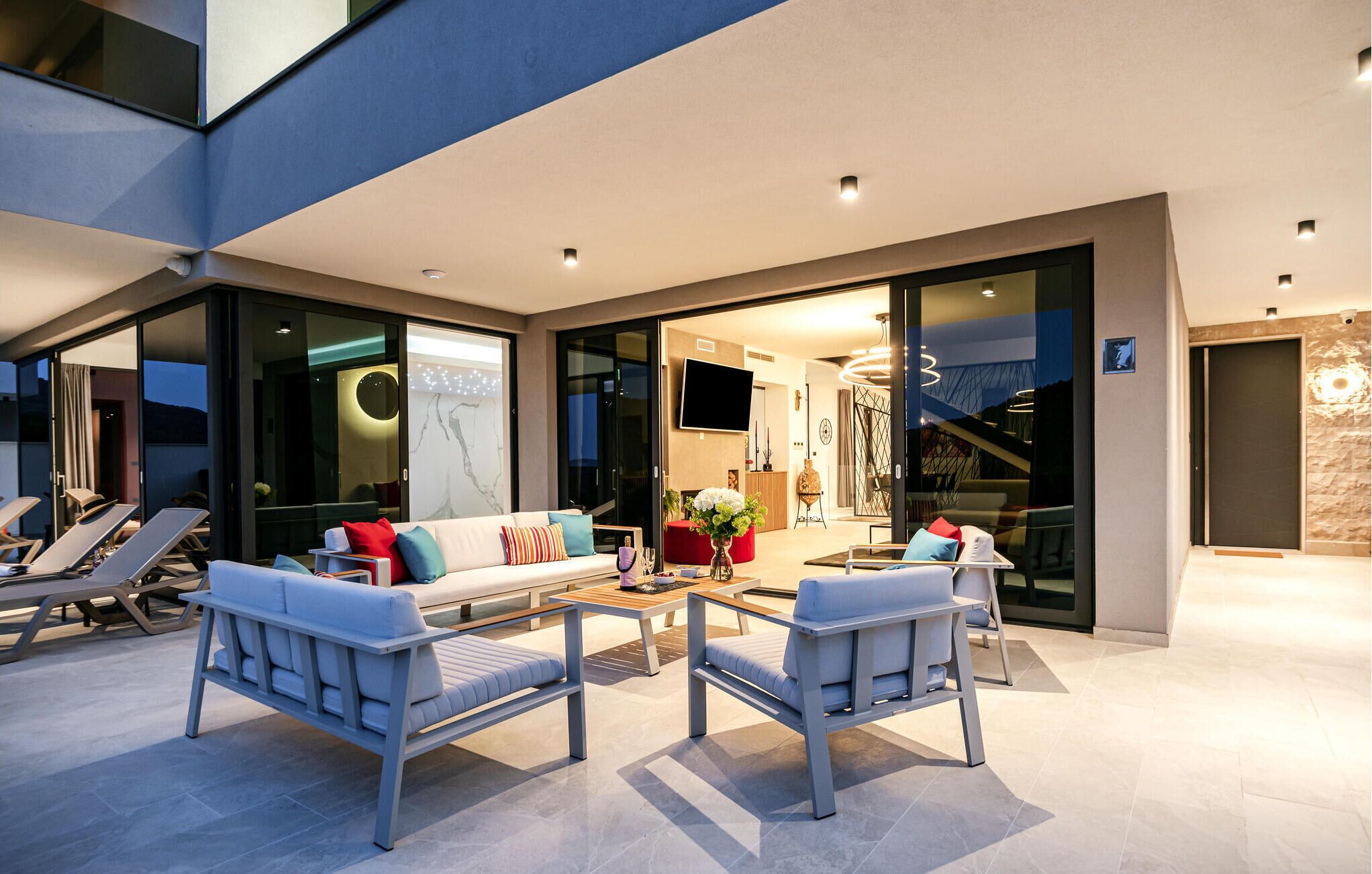 A modern outdoor living area with a sofa, two armchairs, and a coffee table.