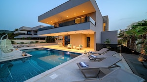 A modern two-story house with a swimming pool, outdoor seating, and a balcony. - Beautiful home in Marina with sauna (Marina)