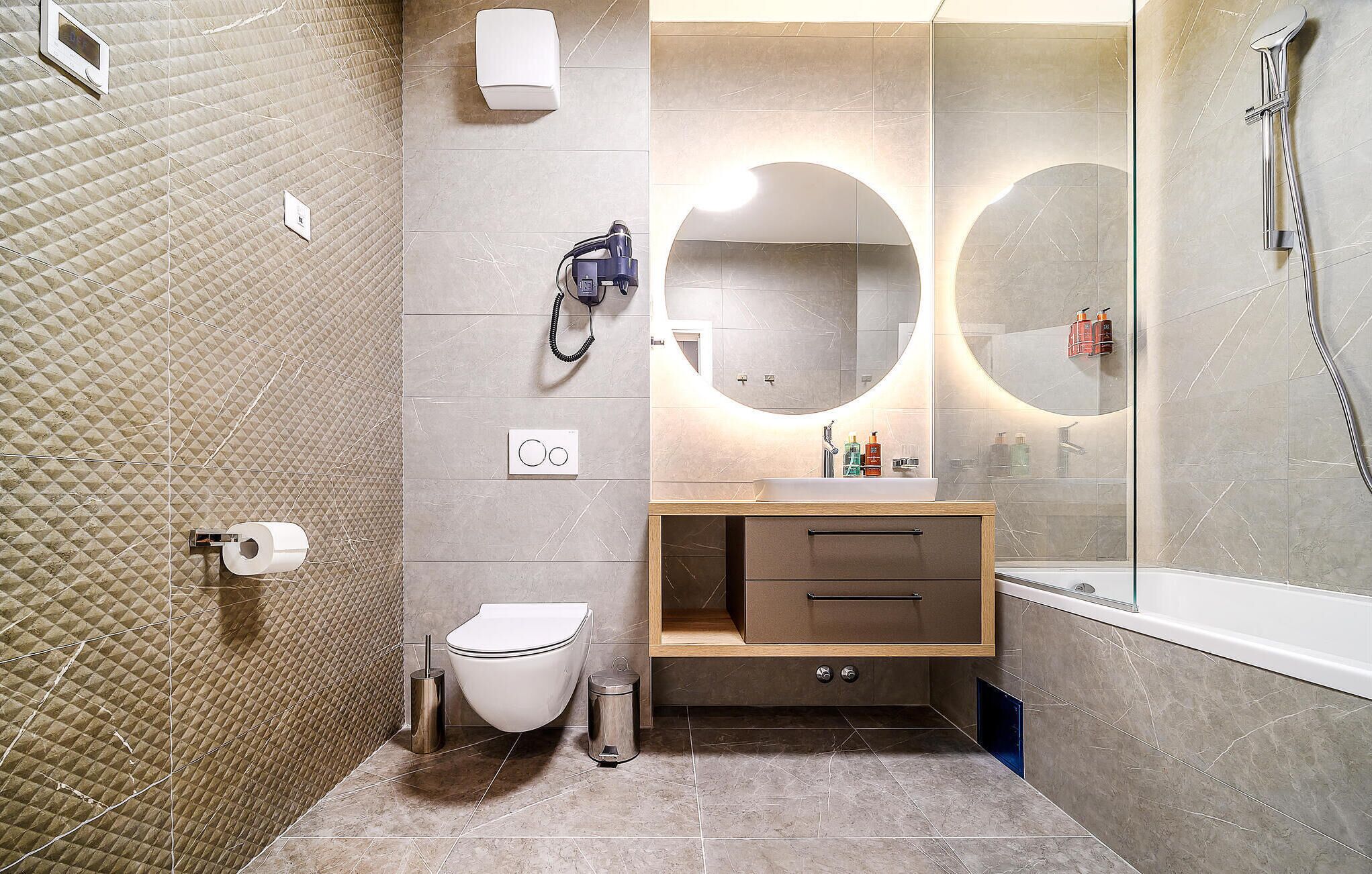 Une salle de bain moderne équipée de toilettes, d’un lavabo et d’une douche.