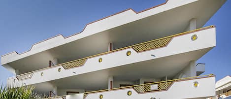 Un edificio de varios pisos con techo plano y balcones.