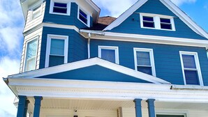 A two-story house with a prominent front porch and a steeply pitched roof.