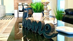 A reception desk with a 'home' sign, a potted plant, and a lamp.