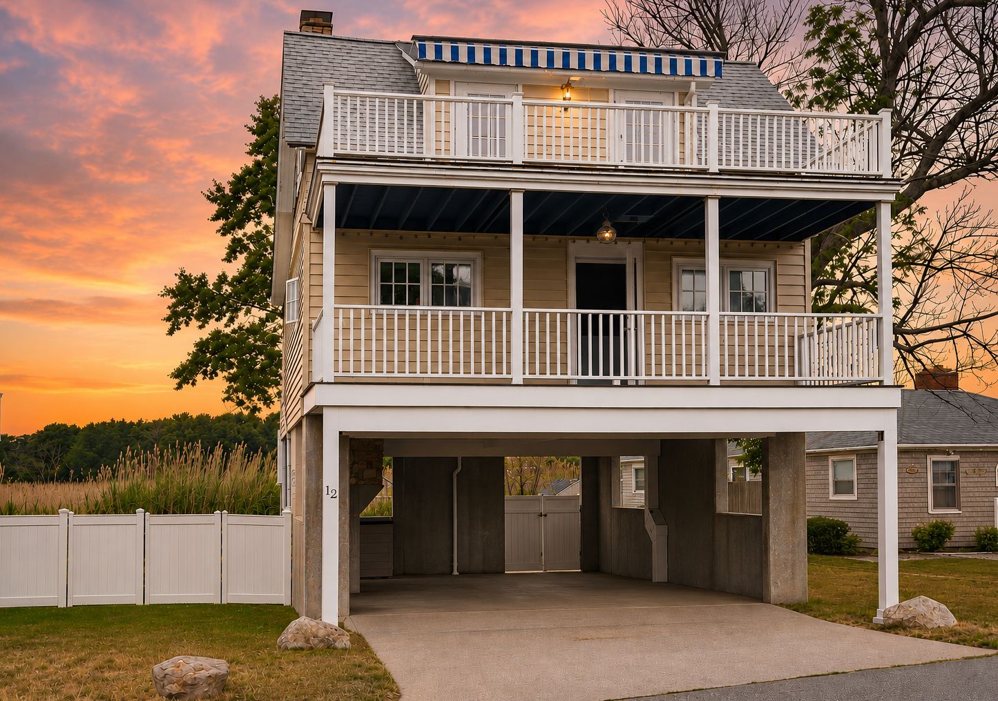 Une maison à deux étages avec un balcon, un garage et une allée couverte.
