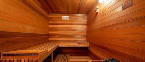Un sauna en bois avec des bancs et un banc muni d’une serviette.