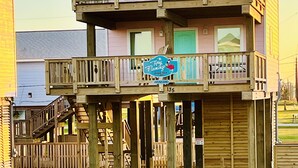 Una estructura de madera de dos pisos con un balcón, un letrero que dice "The Flamingo's" y el número "135" en la fachada.