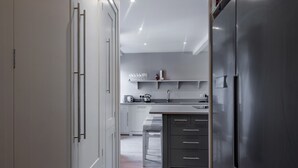 A modern kitchen with a stainless steel refrigerator, wooden flooring, and a built-in oven. - Contemporary Cottage in Ballater Village (Ballater)