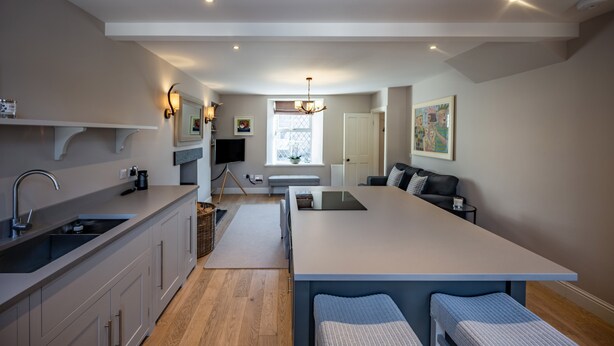A modern kitchen with a central island, a dining area, and a living space. - Contemporary Cottage in Ballater Village (Ballater)