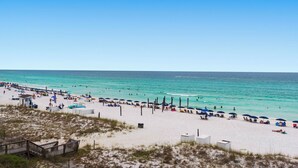 A beach with clear turquoise water, sandy shore, and beach umbrellas. - REMODELED! BeachFront, Bch Service, Pool, wifi, Kitchen, grill (Destin)