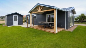 Ett modernt hus med en uteplats och ett litet förråd.