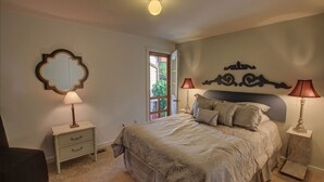 Een slaapkamer met een bed, twee nachtkastjes, een spiegel en een raam.