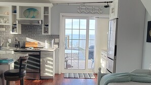 A modern apartment with a kitchen, dining area, and a balcony with a view.