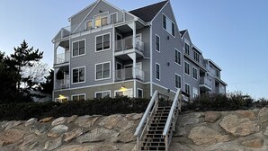 A multi-story beachfront property with a staircase leading to the entrance. - Cape Cod Oceanfront New Condo with Ocean View & Private Beach, OceanBeachVista! (Dennis)