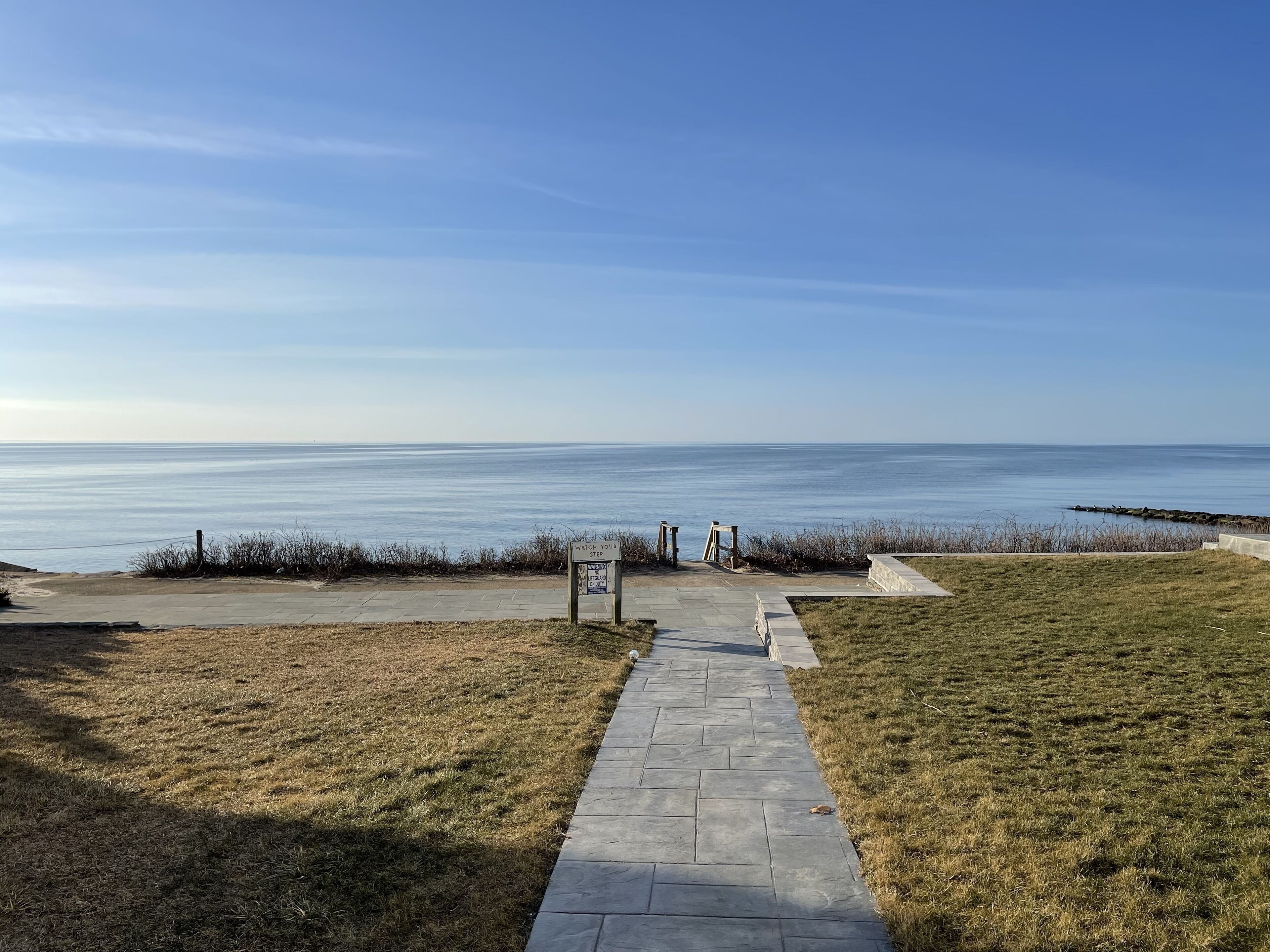 A pathway leading to a beach with a clear view of the ocean.