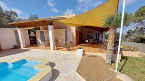 Area piscina con idromassaggio, patio coperto e zona relax con mobili da esterno.