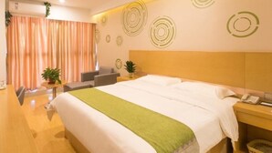 Een hotelkamer met een bed, een bureau, een stoel en een kleine tafel met een plant.