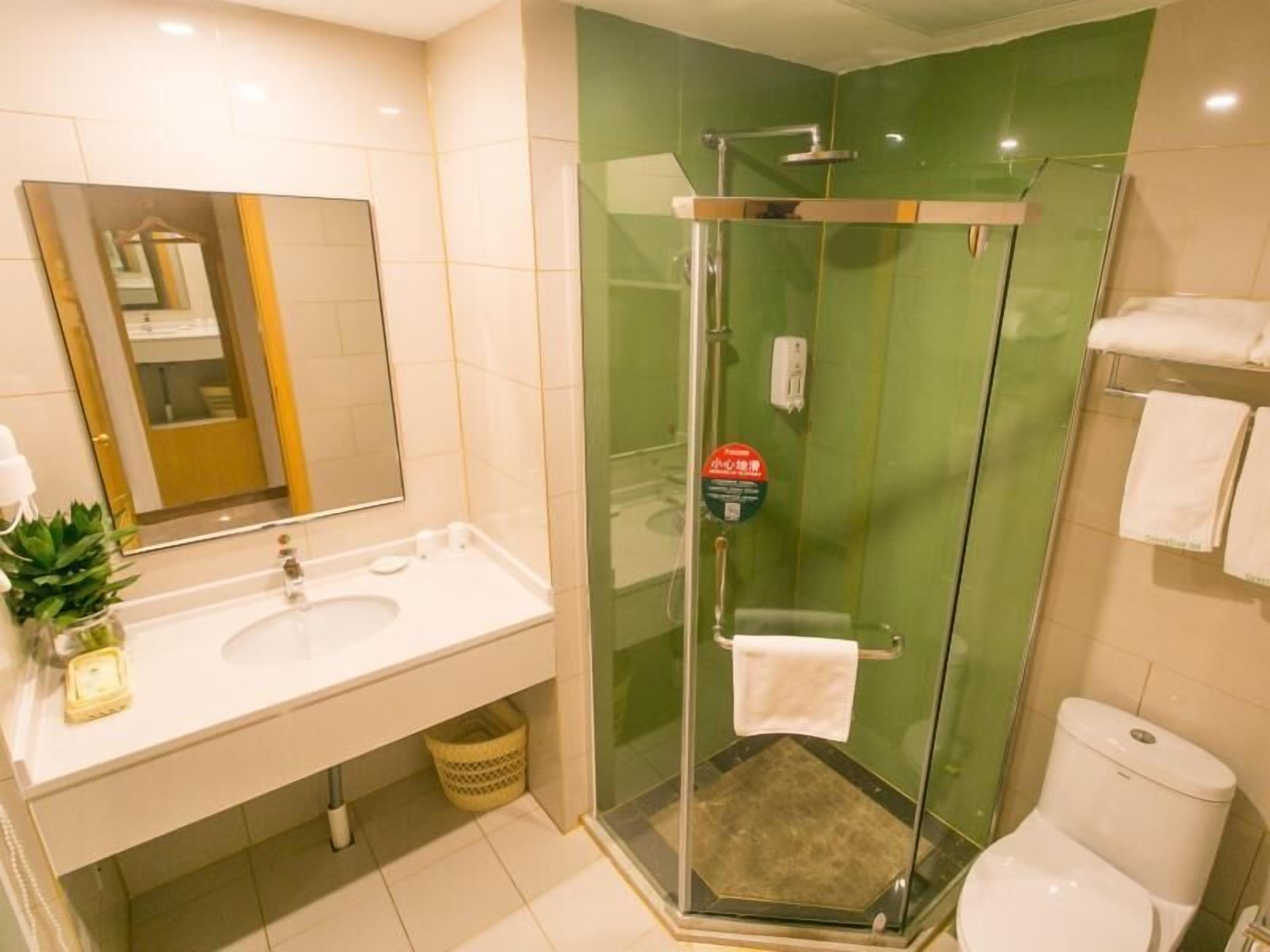 Casa de banho moderna com chuveiro em cabine de vidro, lavatório com espelho e sanita.