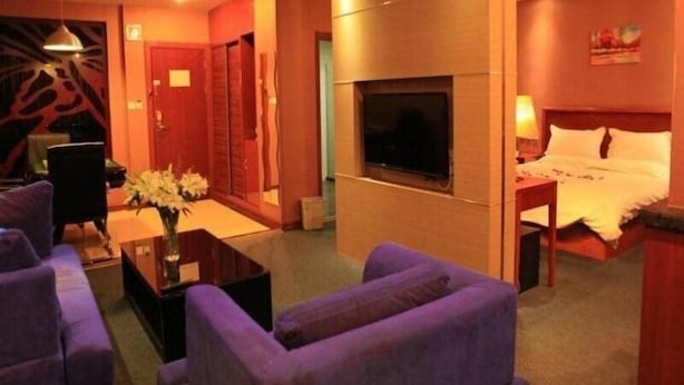 A hotel room with a TV, a bed, a desk, and a sofa. - Greentree Inn Lanzhou Yantan Road Express Hotel (Lanzhou)