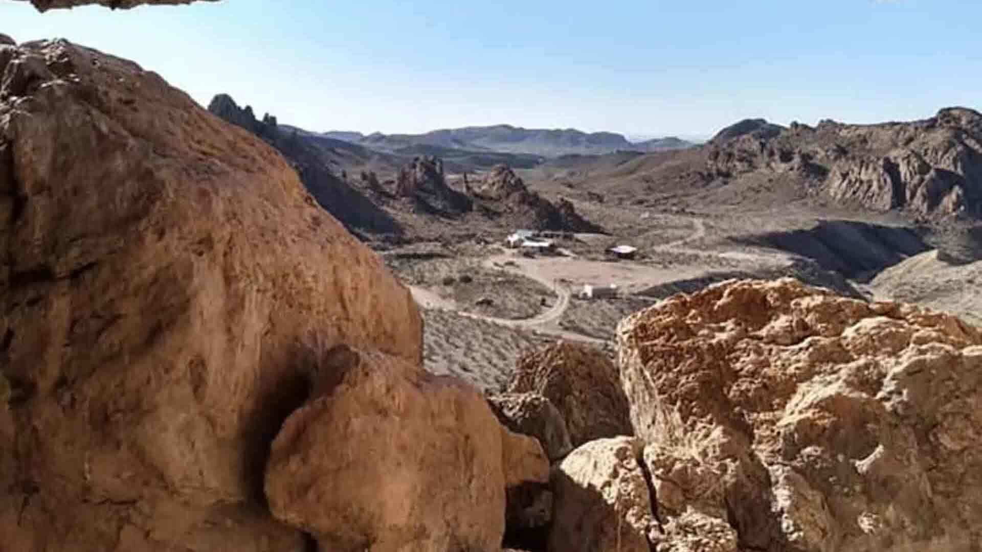 A rugged landscape with rocky terrain and a distant view of a valley.