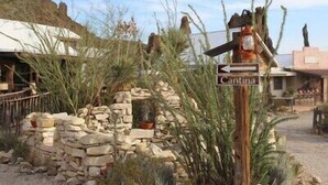 Una pared de piedra rústica con un cartel que indica el camino a Cantina.