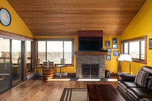 Cozy living room with a fireplace, leather sofa, and flat-screen TV.