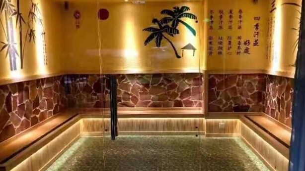 A traditional Japanese onsen with stone walls, a wooden bench, and a water feature. - Greentree Inn Changzhou Wujin Bus Station (Changzhou)
