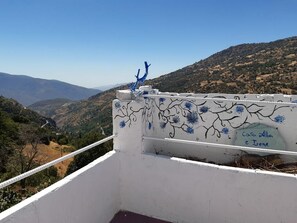 A balcony with a white railing, blue decorative elements, and a sign reading 'Casa Alba e Irene'.