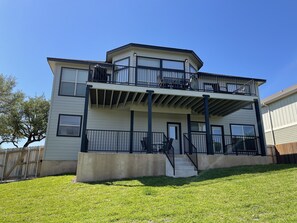 A two-story house with a balcony and a covered porch.