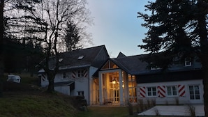 A house with a large front porch, a garage, and a covered outdoor area. - Vacation home for 12 people, 8 rooms, 4 bathrooms with fireplace and large lounge (Altenberg)