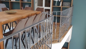 A multi-level living space with a dining area, bookshelves, and a sofa. - Vacation home for 12 people, 8 rooms, 4 bathrooms with fireplace and large lounge (Altenberg)