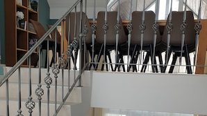 A spacious living area with a modern staircase, a green sofa set, and a patterned rug. - Vacation home for 12 people, 8 rooms, 4 bathrooms with fireplace and large lounge (Altenberg)