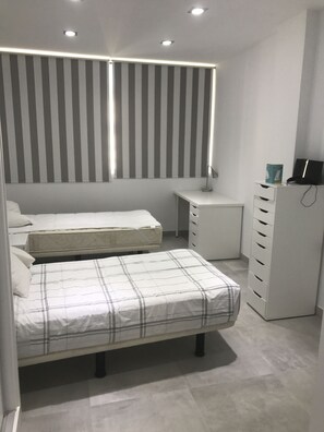 Relax in a spacious bedroom with a large bed, desk, and ample storage.