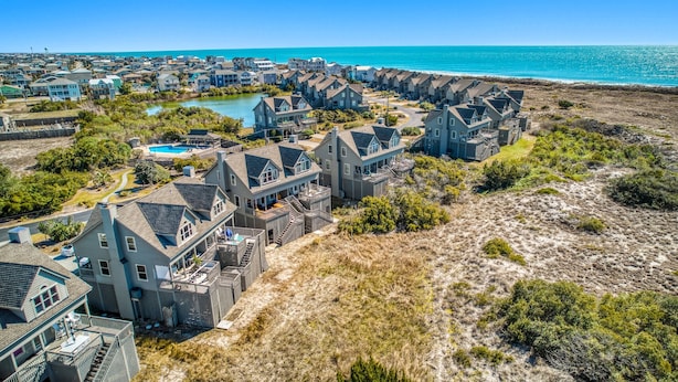 Una zona residencial costera con casas que tienen balcones y una piscina.