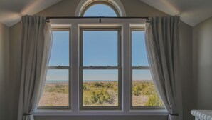 Una habitación con un ventanal que ofrece vistas al paisaje desértico.