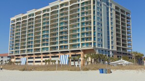 Un hôtel à plusieurs étages doté de nombreux balcons et situé en bord de mer.