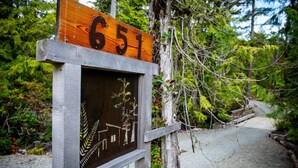 A wooden sign with the number 651, mounted on a post with a metal frame. - #3 CABIN COUPLES KING BED HOTTUB BEACH (Ucluelet)