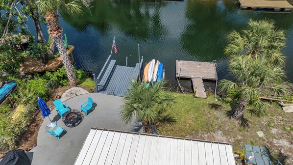 A lakeside deck with a small pool, surrounded by palm trees and a dock. - Waterfront w access to the Weeki Wachee River & Gulf of Mexico - Dog Friendly! (Spring Hill)