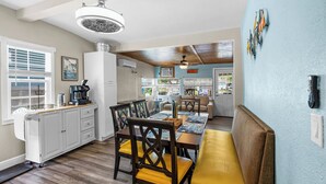 A kitchen with a dining area, featuring a wooden table, chairs, and a bench. - Waterfront w access to the Weeki Wachee River & Gulf of Mexico - Dog Friendly! (Spring Hill)