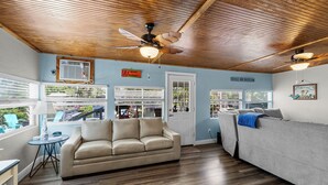 A room with a wooden ceiling, a beige sofa, a grey couch, and a ceiling fan. - Waterfront w access to the Weeki Wachee River & Gulf of Mexico - Dog Friendly! (Spring Hill)