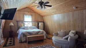 Una stanza accogliente con un letto, un divano, una ventola a soffitto e una finestra.